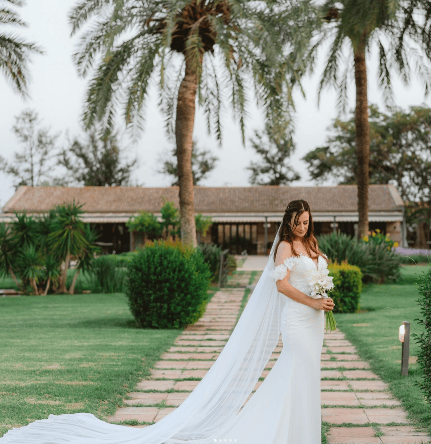 Woman in wedding dress with palm trees behind after completing training with bride to be coach | bride to be workout